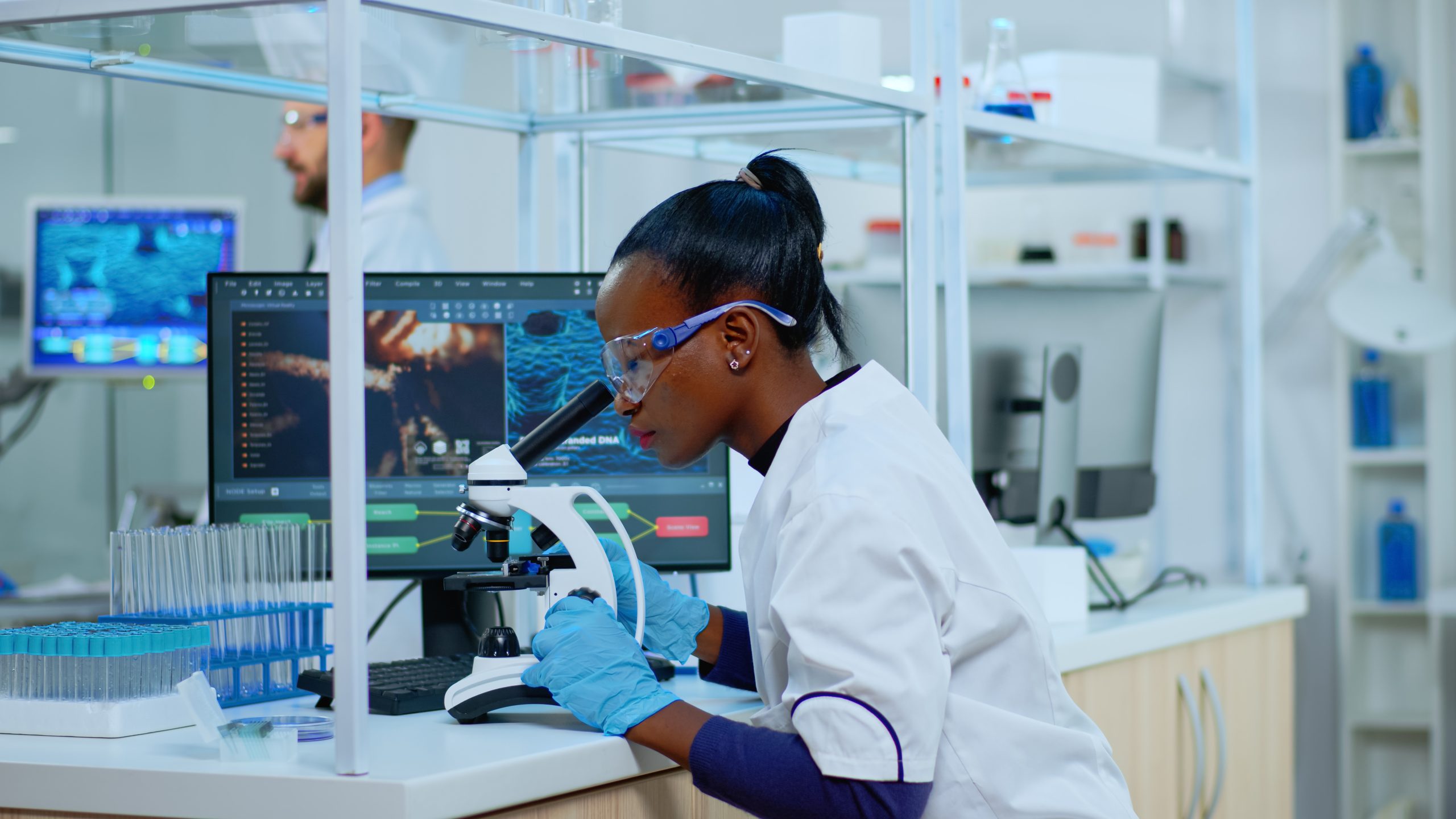 African scientist checking sample of virus using microscope African scientist checking sample of virus using microscope